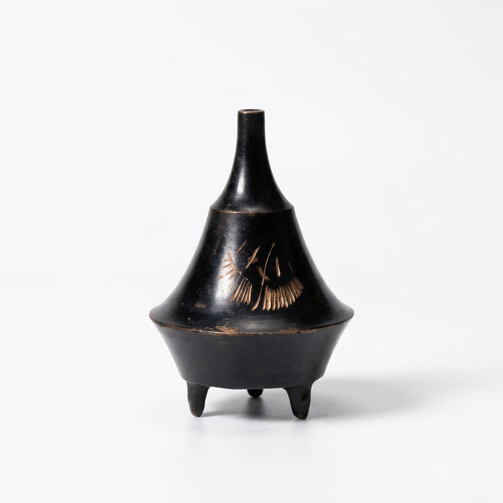 Mini metal cone incense burner in black with an etched gold leaf design and three small feet