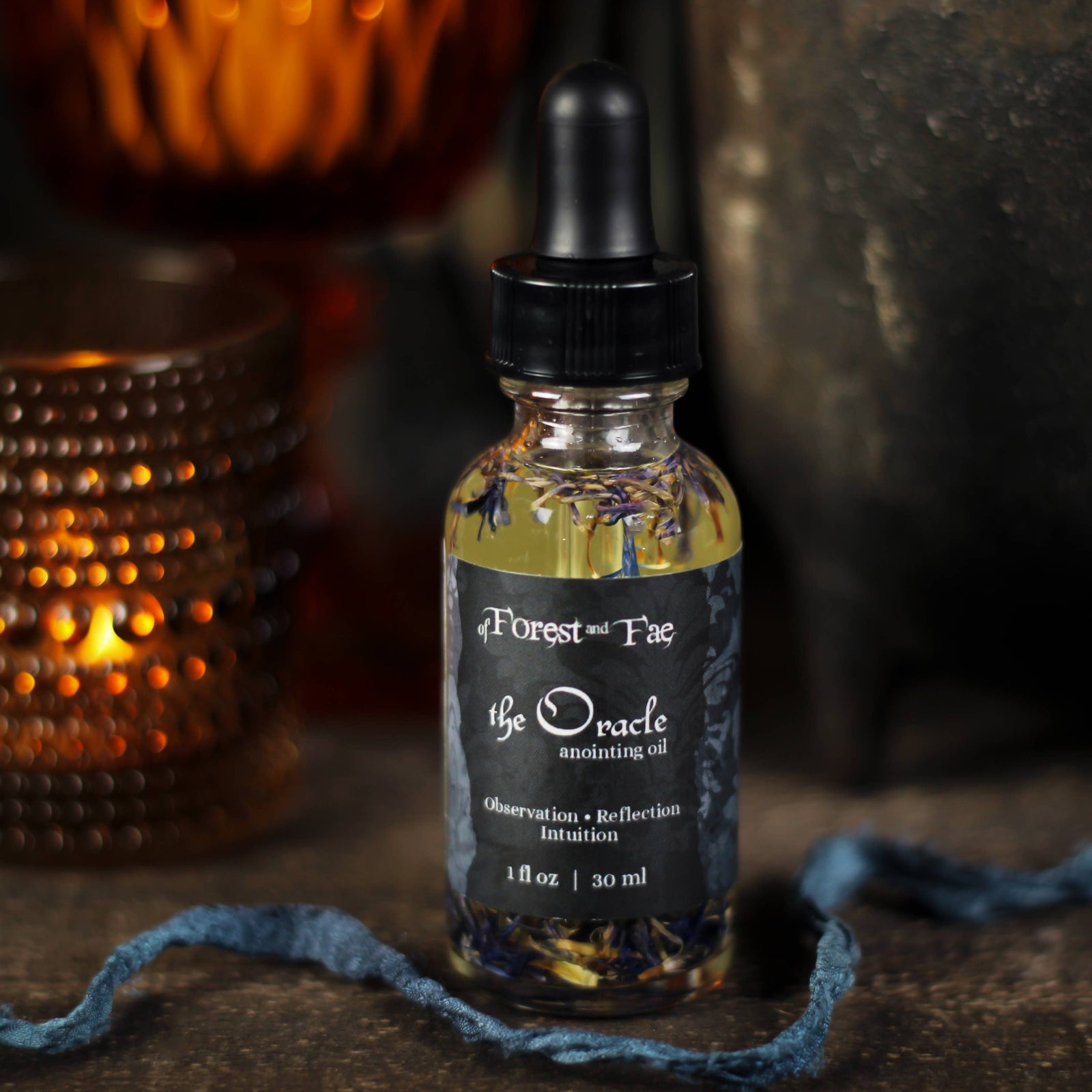 The Oracle anointing oil bottle labeled Observation, Reflection, Intuition with a blue ribbon
