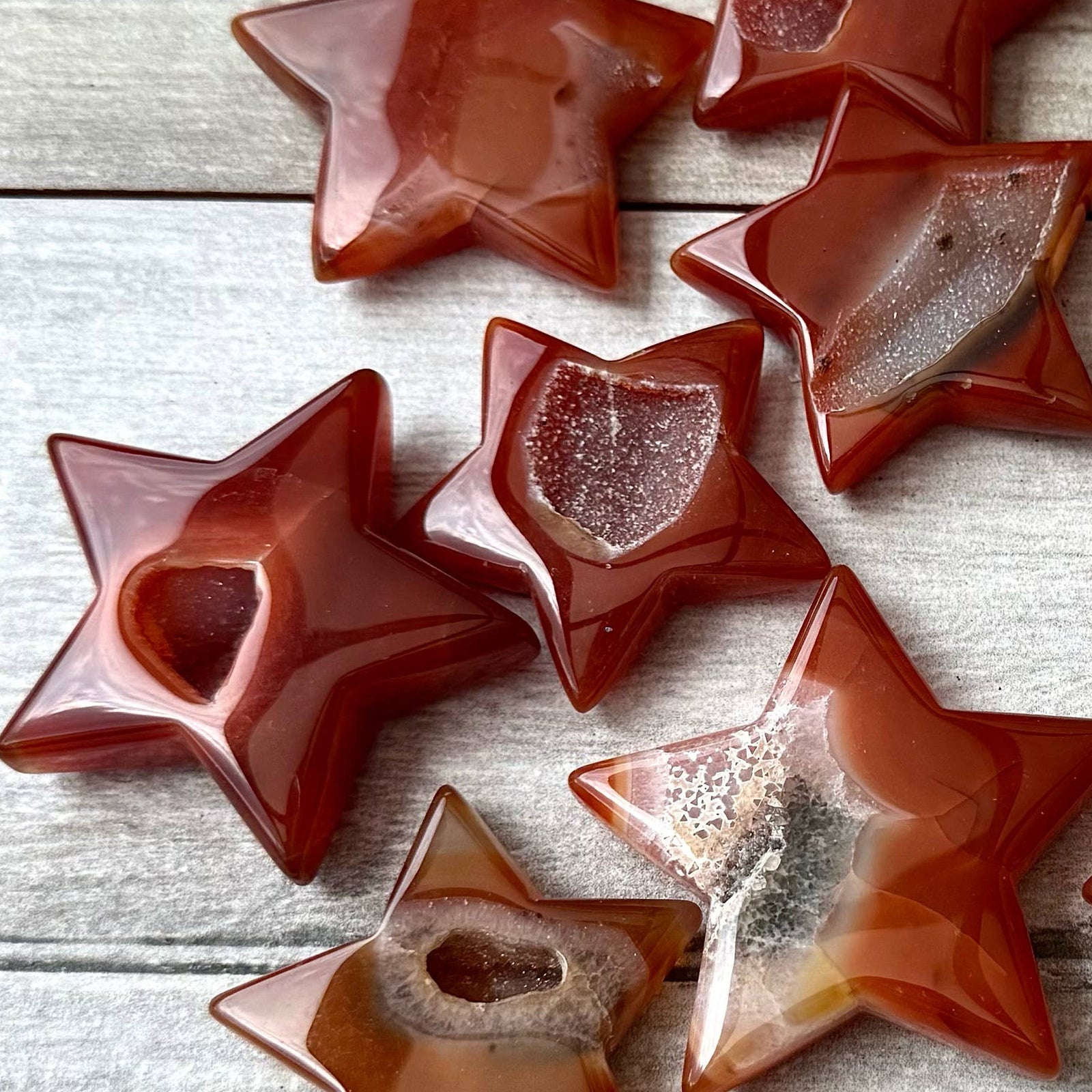 Star-shaped brown and beige stones on a wooden surface.