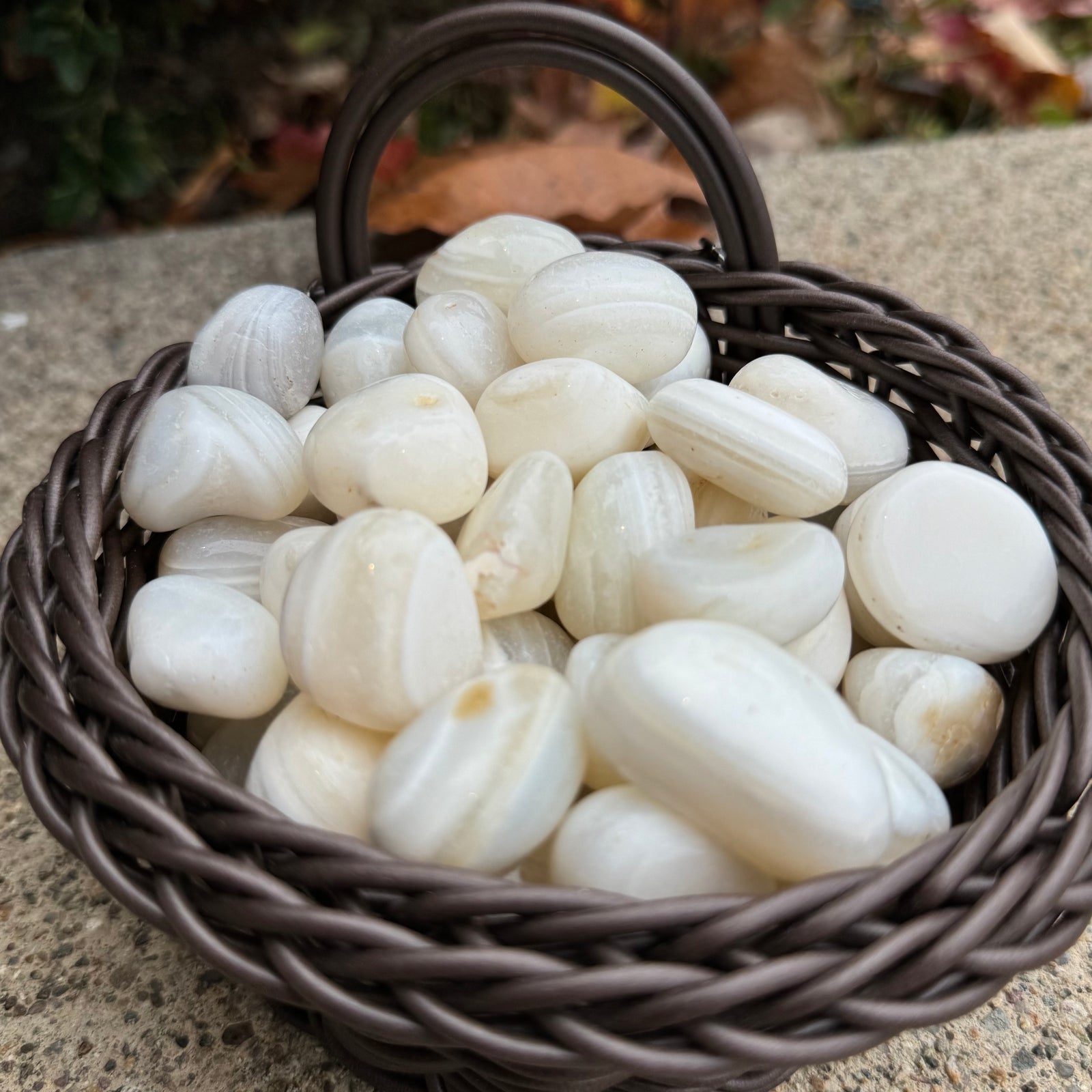 Basket filled with white stones on a concrete surface