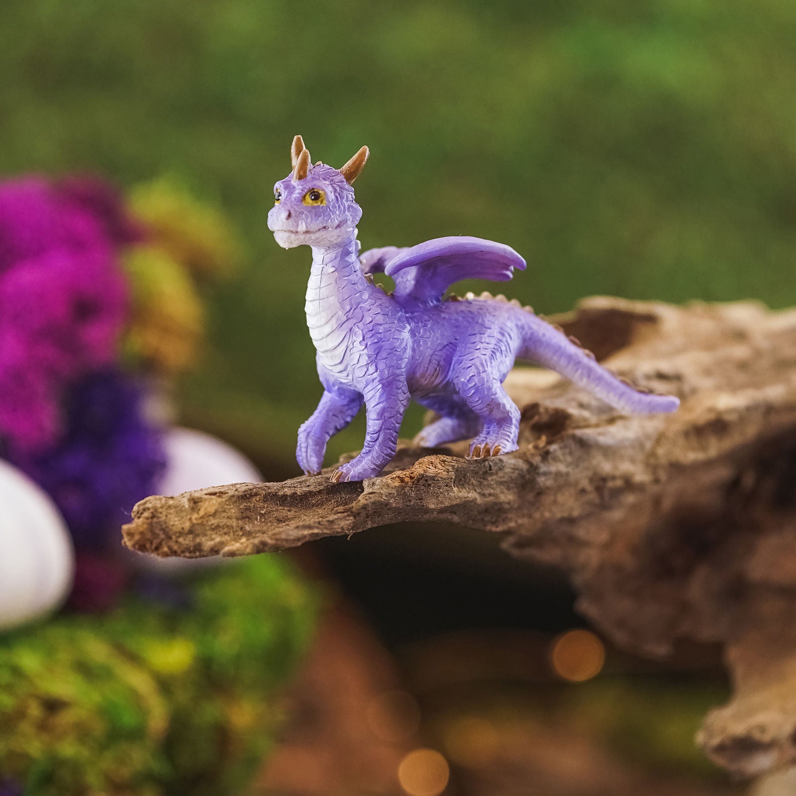 It is standing on all fours and has a simultaneously adorable and majestic appearance. He has purple scales and a white underbelly, along with yellow eyes, three horns on its head, and a ridge of spikes down the winged back. It’s a lovely dragon that will be at home anywhere.