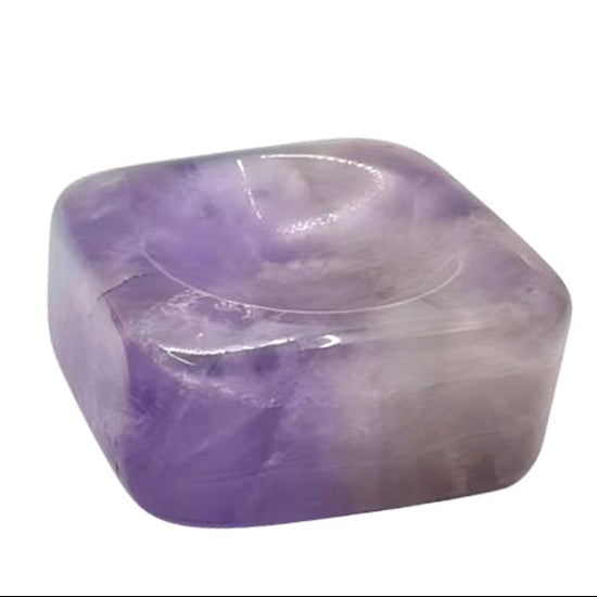 Three purple and gray marbled stones on a white background