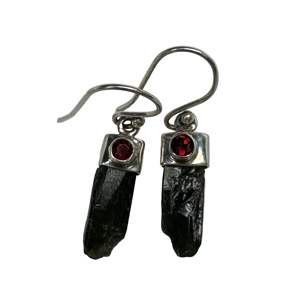 Pair of earrings with green stones and red gemstones on a white background