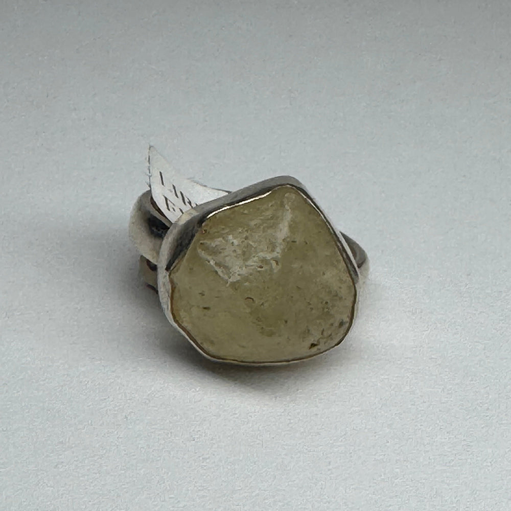 Silver ring with a stone on a light gray background
