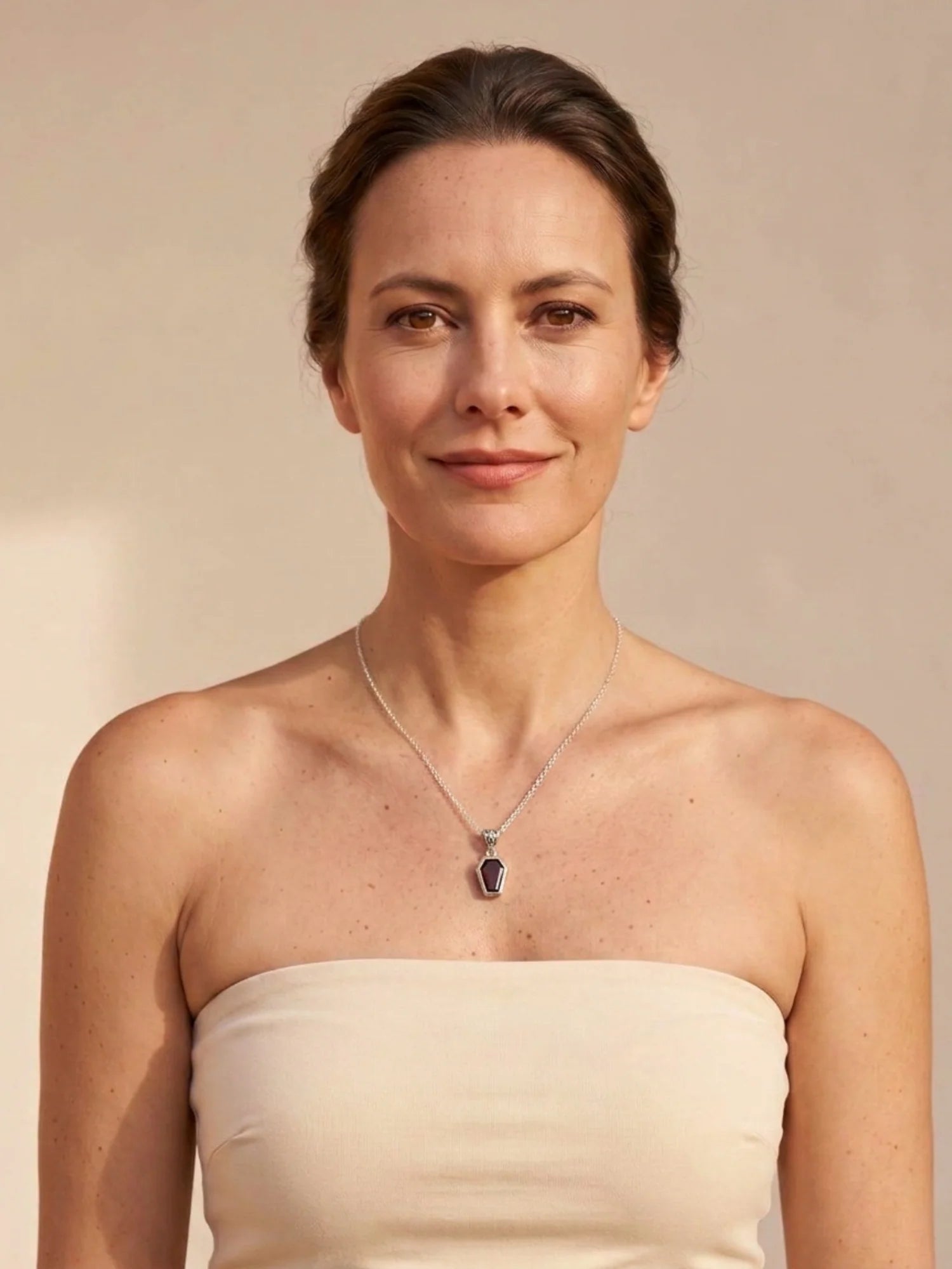 Woman wearing the Silvaria garnet coffin necklace on its silver chain