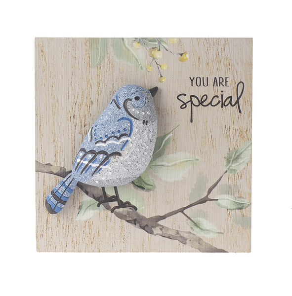 Decorative stone with a bird design and 'You are special' text on a wooden background