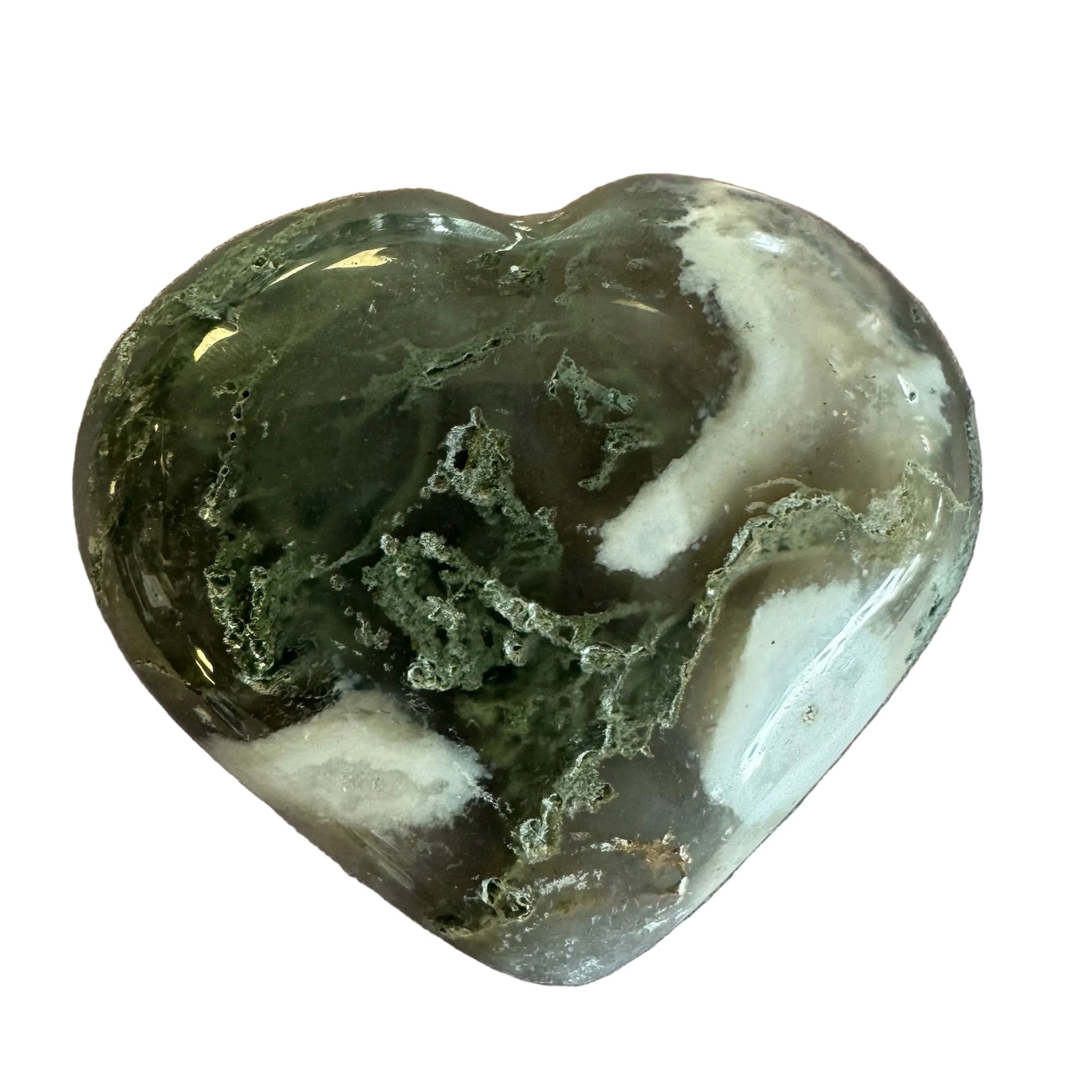 A polished heart-shaped crystal stone with natural marbled patterns of dark green, translucent gray, and white, resting on a textured light brown surface.