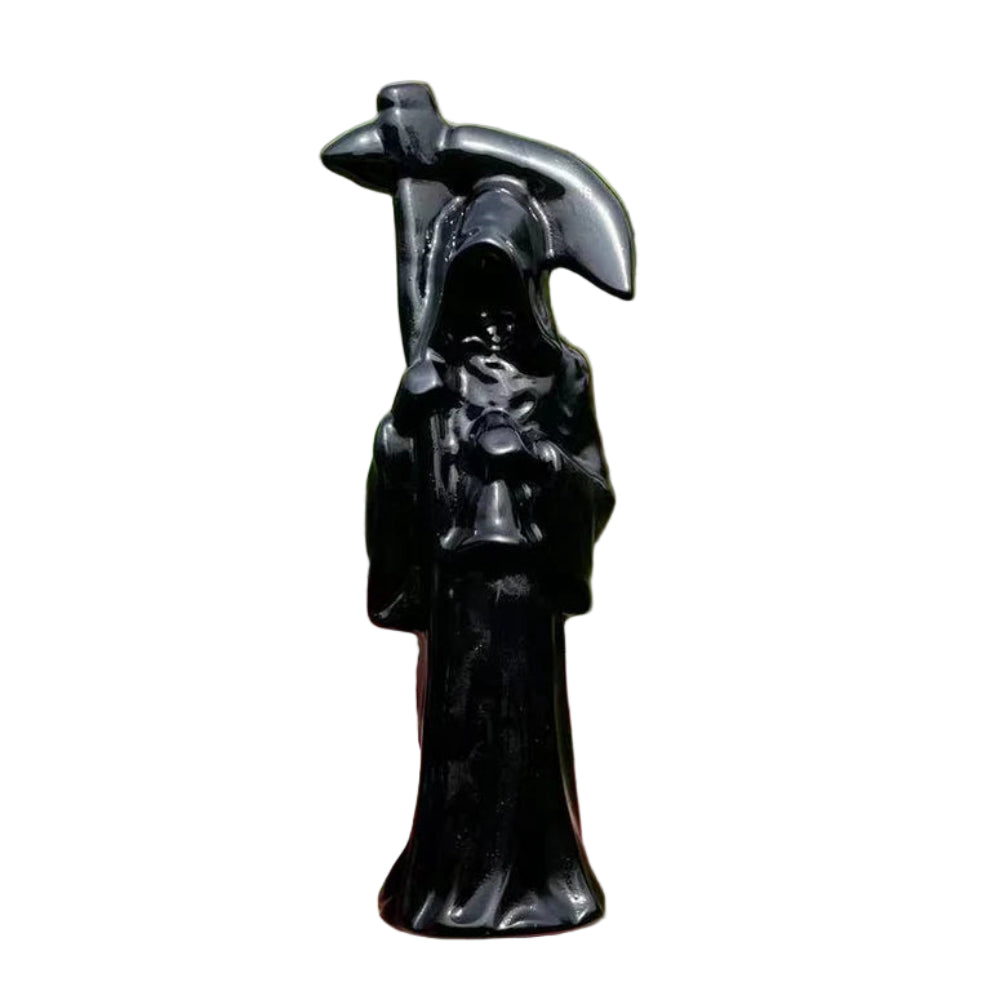 Black sculpture of a figure holding an axe against a natural background