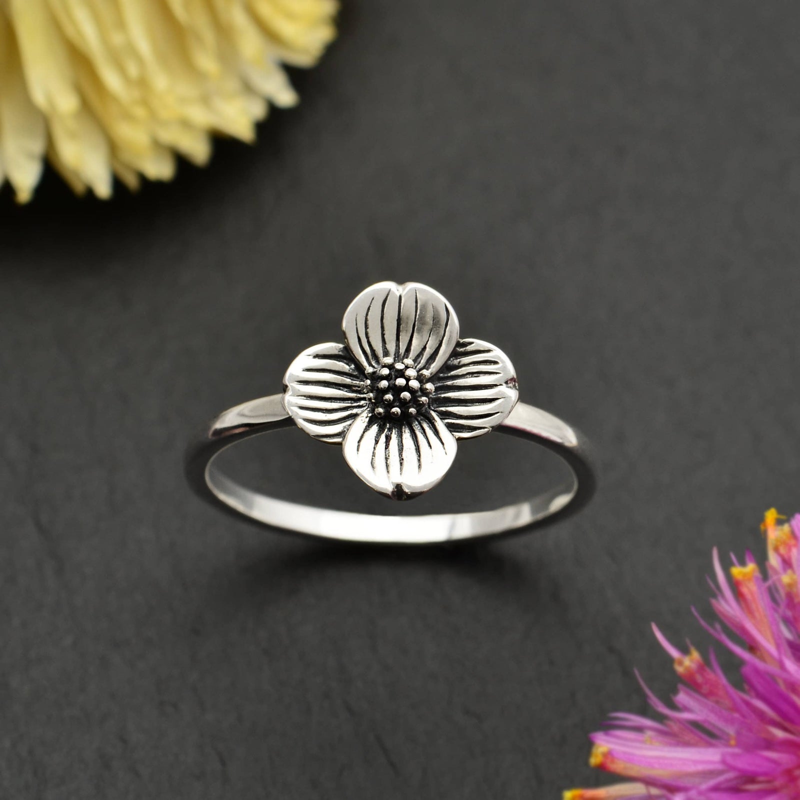 This sterling silver dogwood flower ring features delicately detailed, layered petals and a clustered center, deeply oxidized to add depth and contrast. In flower symbolism, dogwoods are thought of as sacrifice, strength, rebirth, and purity. 