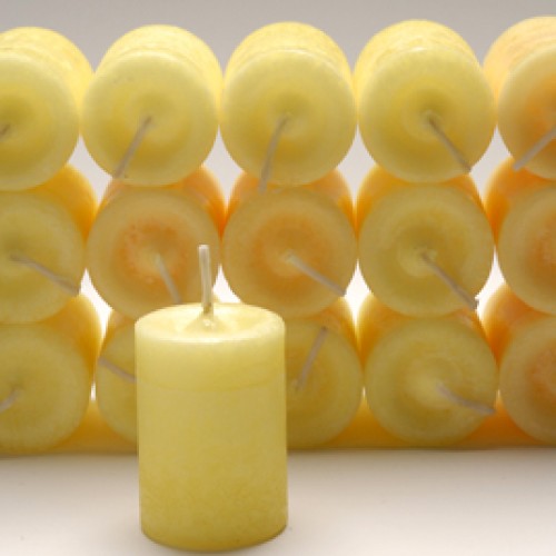 Yellow candles with visible wicks arranged in a pattern on a white background