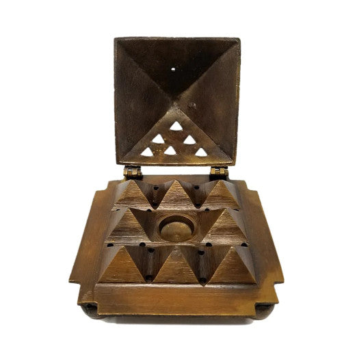 A golden pyramid shaped incense burner with the Eye of Horus symbol on one side, and an open hinged door revealing 8 pyramids inside with holes for stick and cone incense.
